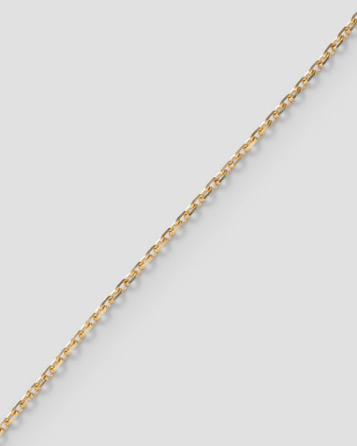 Diamond cut mirror chain, 1.0 mm, in 18k recycled yellow gold, laid diagonally on a pale ground.