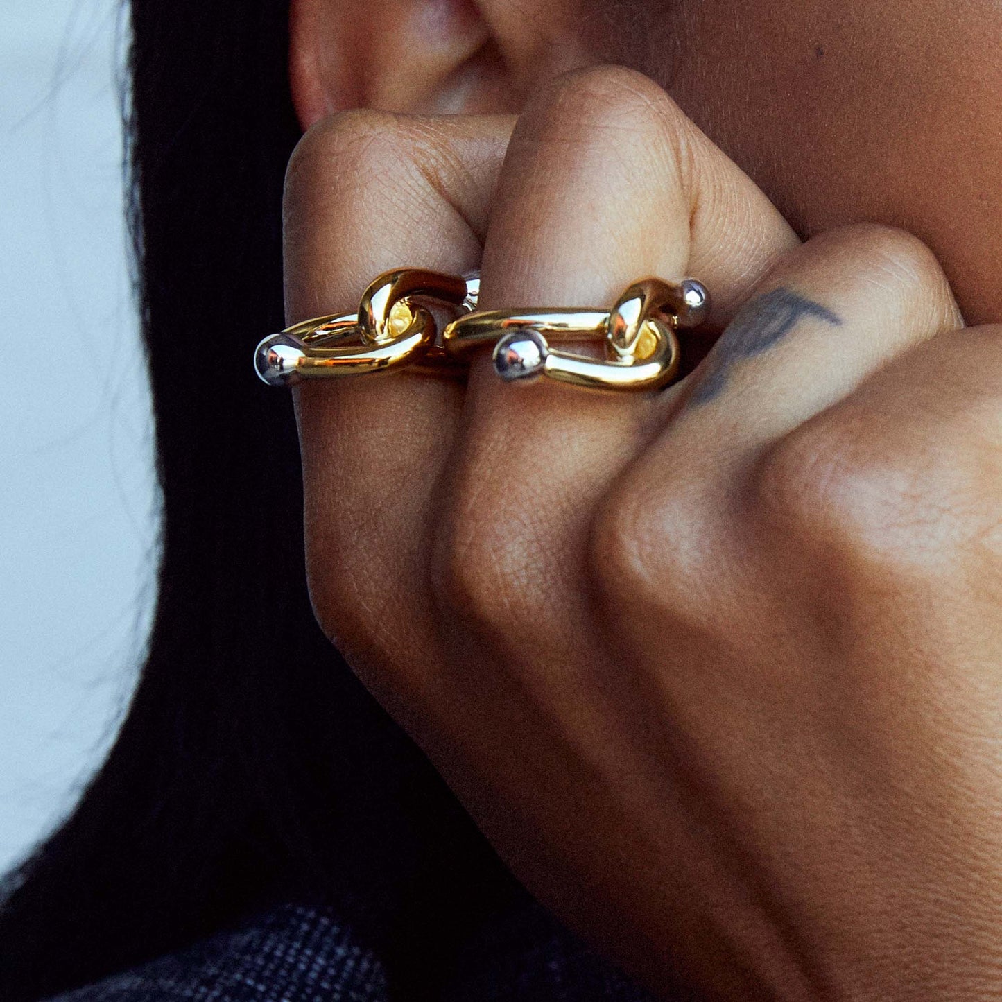 two falcate rings in gold from ennui atelier on hand